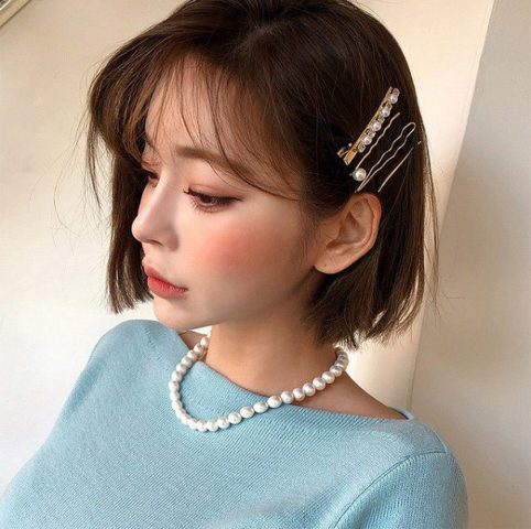 Tóc bob ngắn cổ điển được điểm xuyết kẹp tóc tiểu thư, tạo nên vẻ đẹp nữ tính và sang trọng cho buổi tiệc
